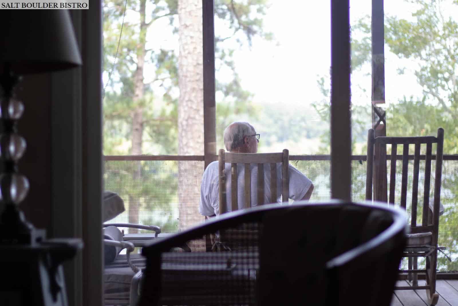 man sitting on chair near empty chair indoors